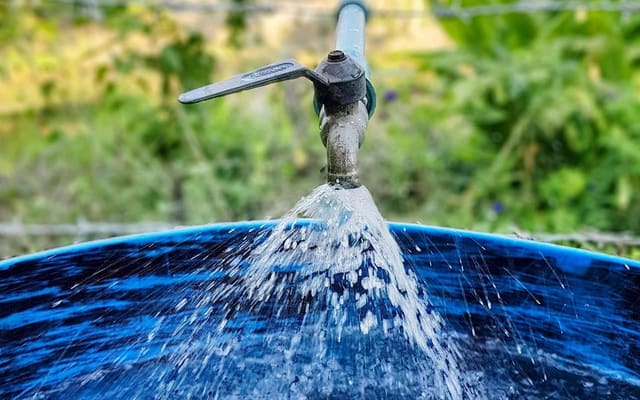 Água limpa enchendo uma caixa d'água azul